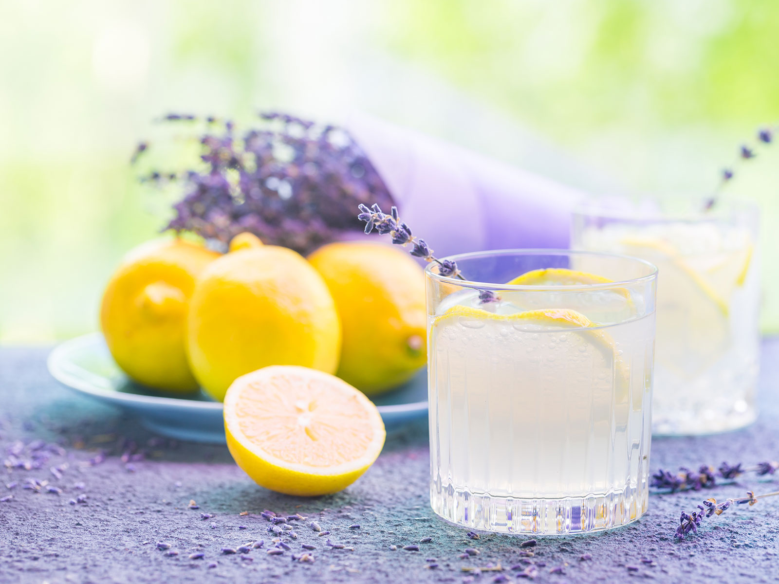 lavender lemonade in a glass with lemon slices and lavender sprigs
